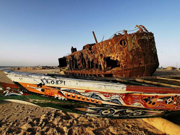 Une épave et une barque sur une plage mauritanienne