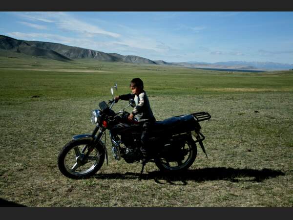 A Tsagaannuur, dans la province de Khövsgöl, la plupart des habitants se déplacent en moto, comme le père de ce jeune garçon (Mongolie).