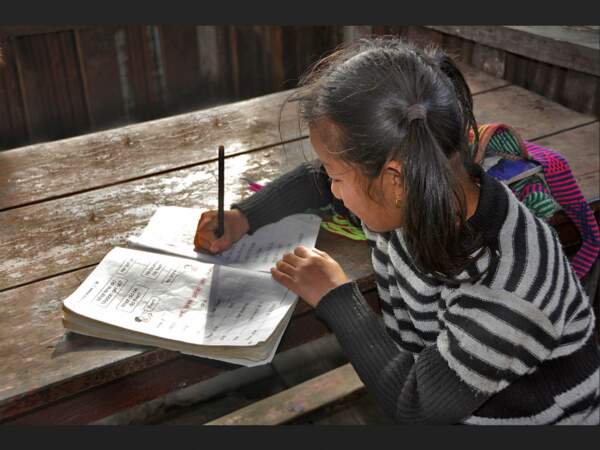Une petite fille fait ses devoirs dans le village de Chimrung, au Népal.