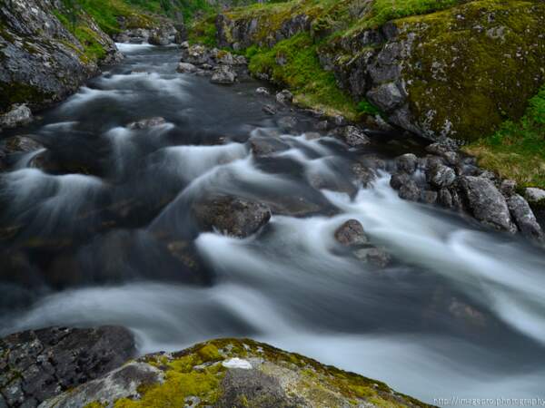 Une rivière coule vers Tind, sur les îles Lofoten, en Norvège