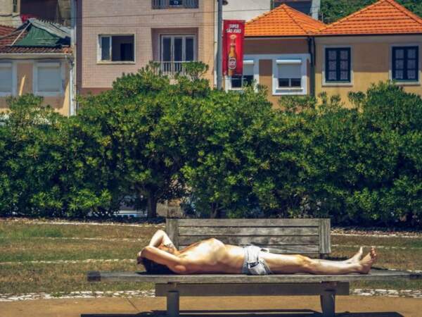 Homme profitant du soleil sur la promenade qui longe le cours du Douro, vers Porto, au Portugal. 