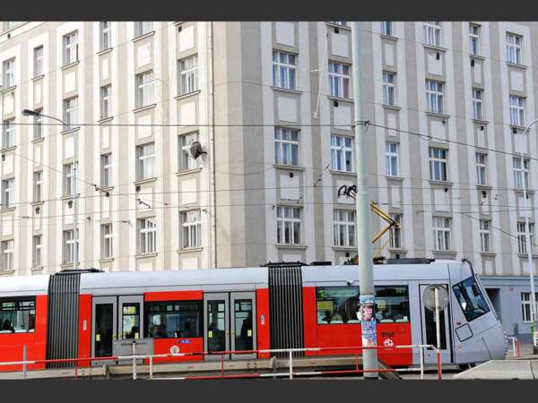 A Prague, un tramway passe devant une façade austère qui rappelle l'esthétique soviétique (République tchèque).