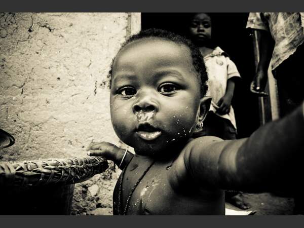 Ce jeune enfant du Togo observe l'appareil photo avec curiosité.