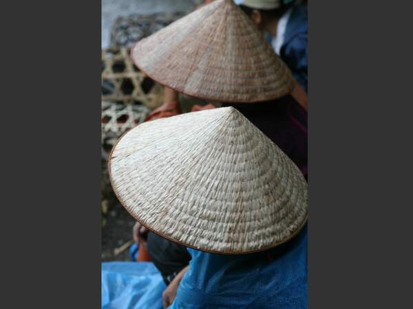 Ces marchands sont coiffés du chapeau traditionnel du Vietnam, en forme d'accent circonflexe.