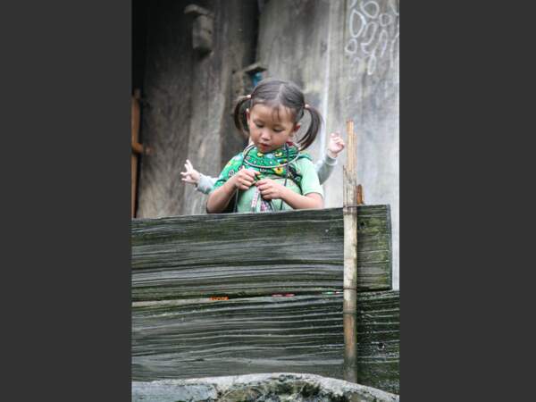Cette fillette qui porte son frère sur le dos fait partie de l'ethnie Hmong (Vietnam).