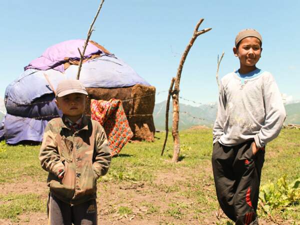 Deux enfants se tiennent près de la yourte où ils vivent, dans le massif du Ferghana, au Kirghizistan