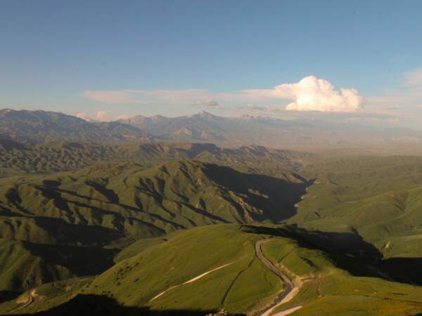 Vue sur le relief verdoyant de l'autre côté du col, dans le massif du Ferghana, au Kirghizistan