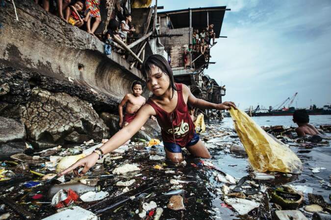 Une fillette ramasse les déchets plastique dans les eaux marines de Manille, aux Philippines, en 2019
